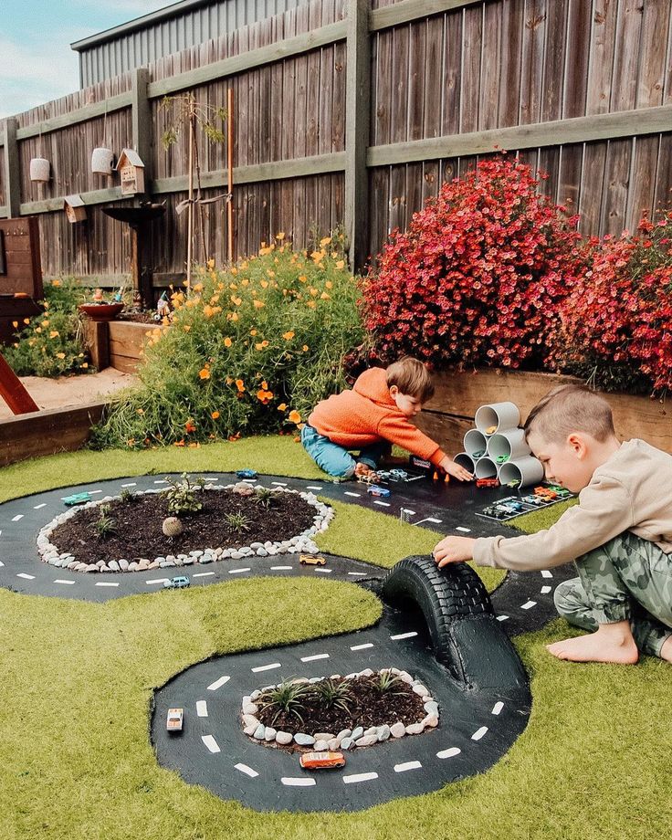 two young boys playing with toy cars in the yard