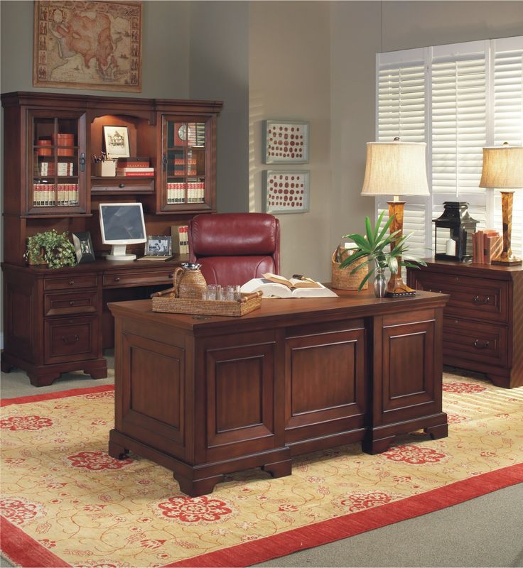 an office with a desk, chair, and bookcase in the middle of it