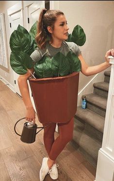 a woman is holding a potted plant in her hand and wearing leggings