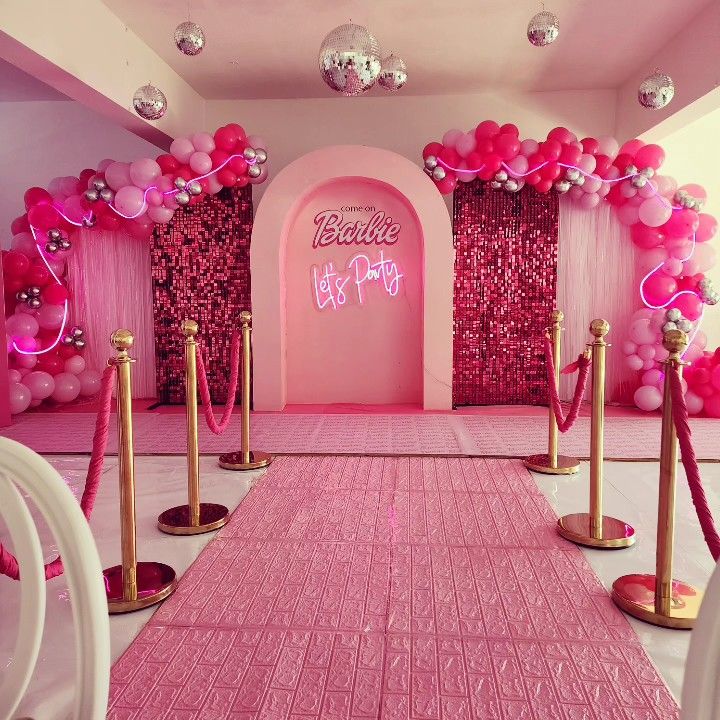 a pink and gold party setup with balloons