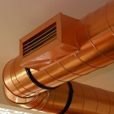 an air conditioner mounted on the side of a ceiling in a room with white walls