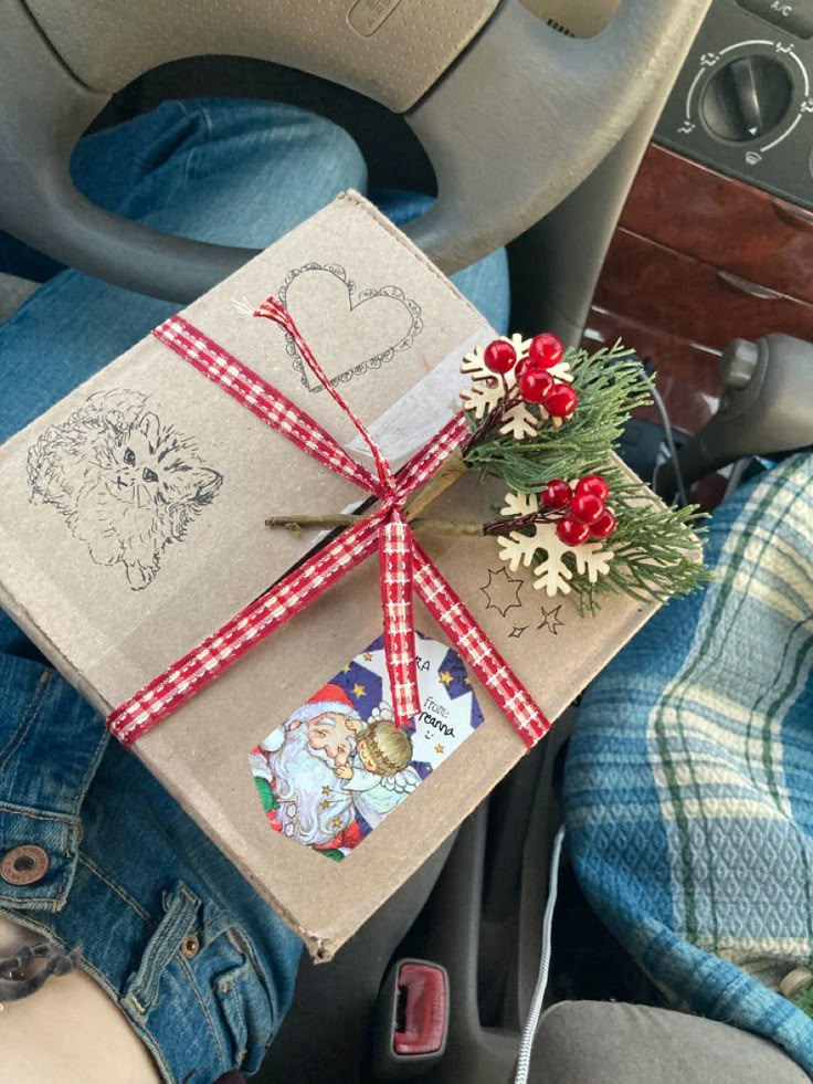 a gift wrapped in brown paper and tied with red ribbon sitting on the front seat of a car