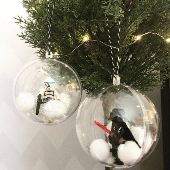 star wars ornaments hanging from a christmas tree with lights and snowballs in them,