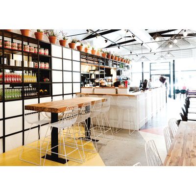 the interior of a restaurant with tables, chairs and shelves full of bottles on display