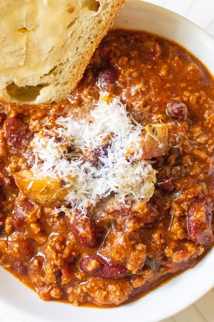 a white bowl filled with chili and bread