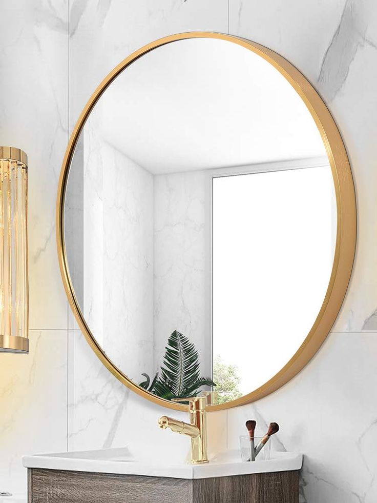 a bathroom vanity with a round mirror above it