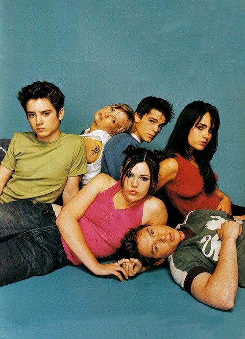 a group of young people sitting next to each other in front of a blue background