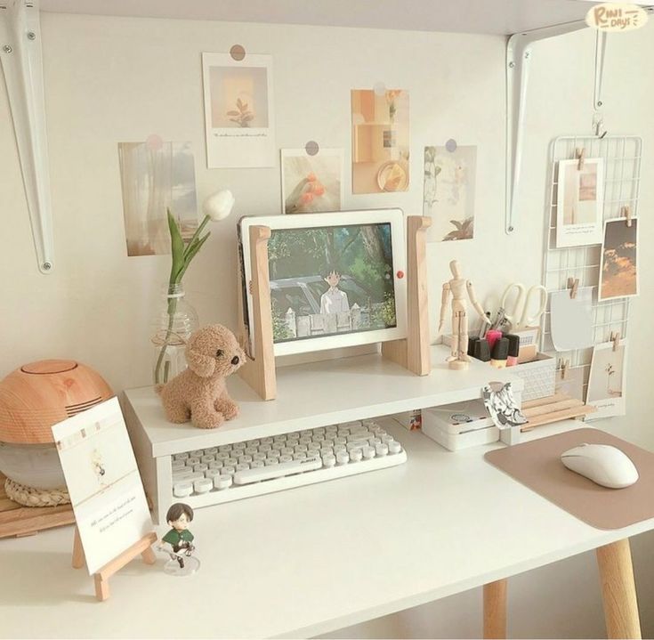 a desk with a computer, keyboard and teddy bear on it in front of a window