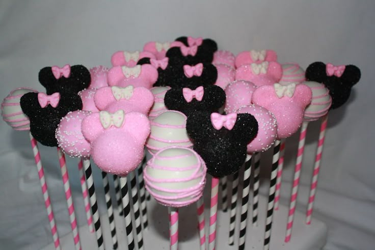 there are many minnie mouse cake pops on the table