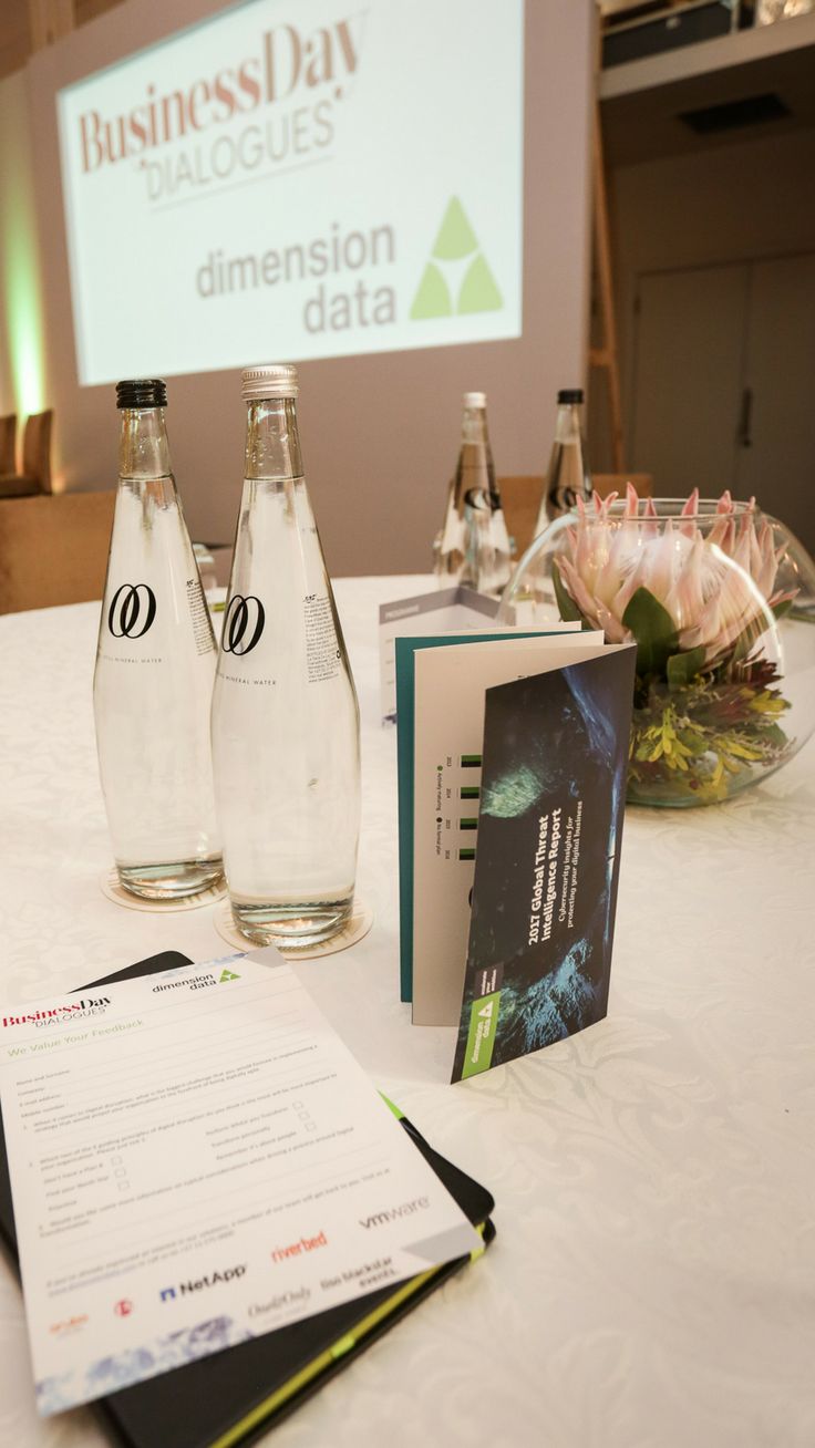 two water bottles sitting on top of a table next to a menu and some books