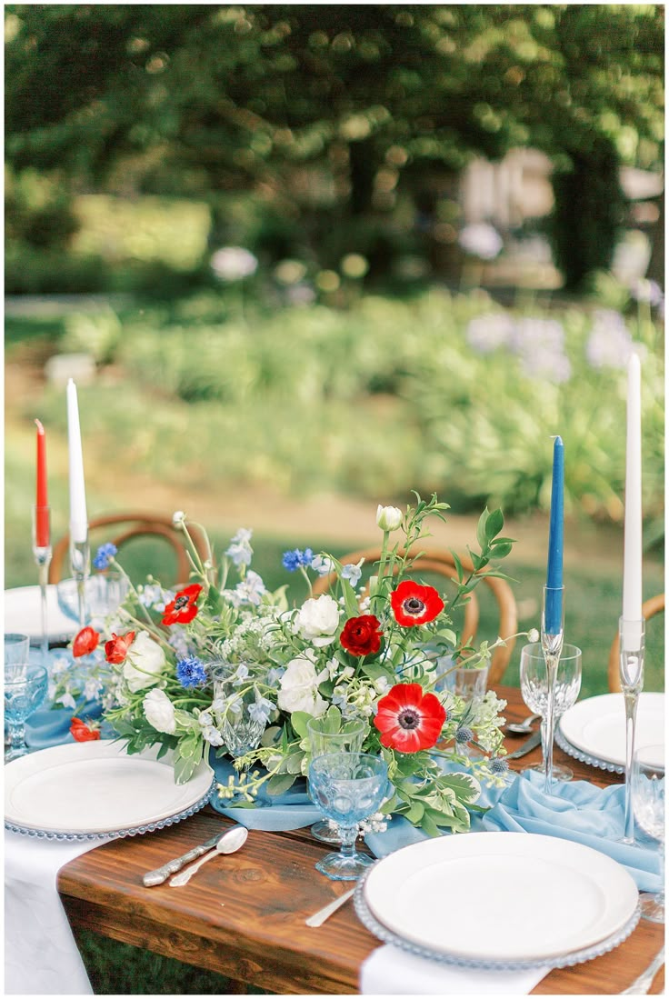 the table is set with red, white and blue flowers