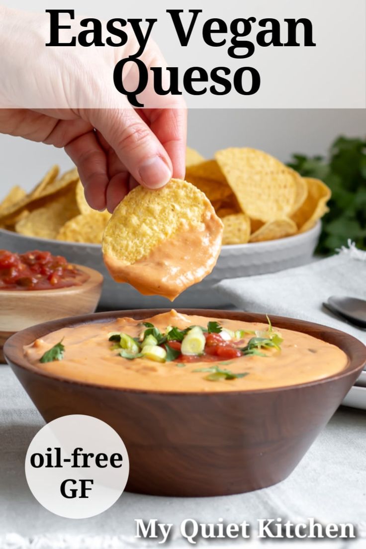 a hand dipping a tortilla chip into a bowl of quesadilla