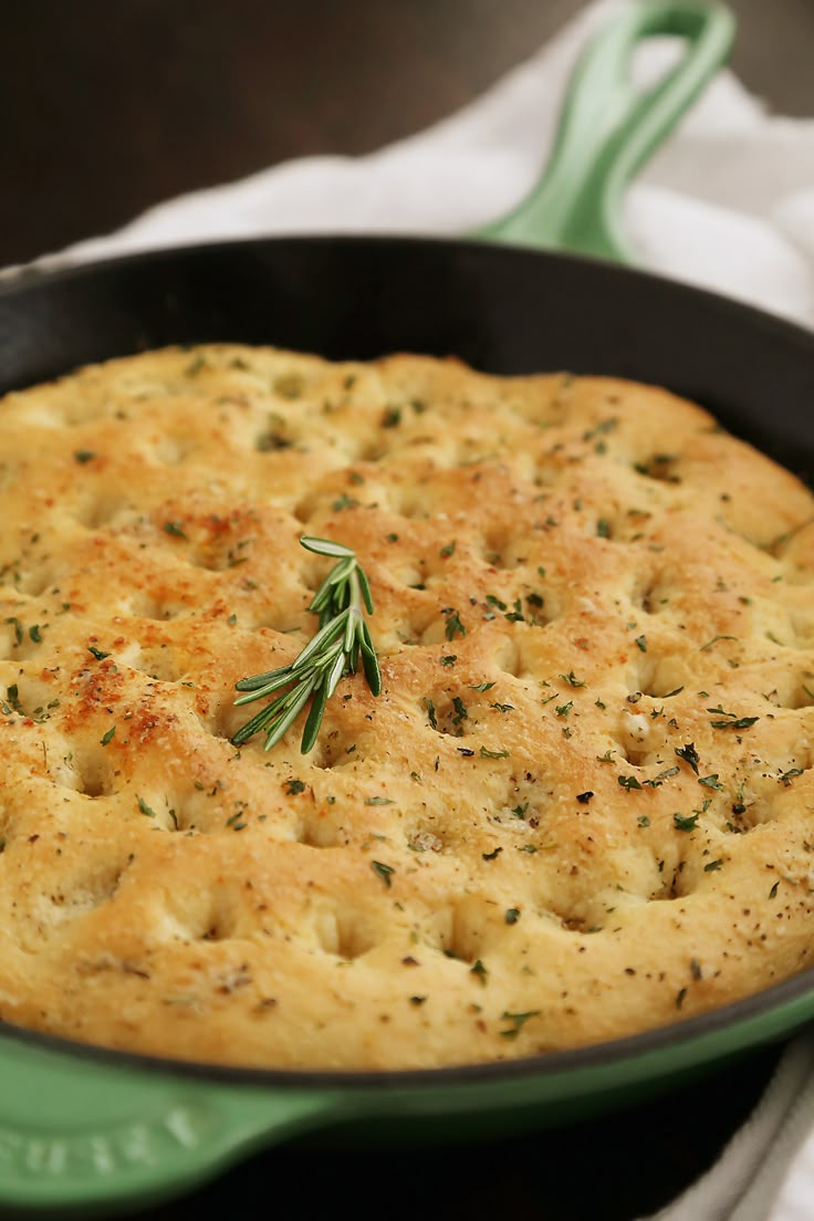 a close up of a skillet with food in it on a towel next to a spoon