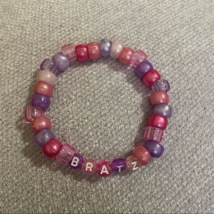 a beaded bracelet with the word bratz written in pink, purple and red beads