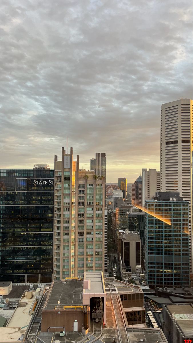 a city skyline with tall buildings and cloudy skies