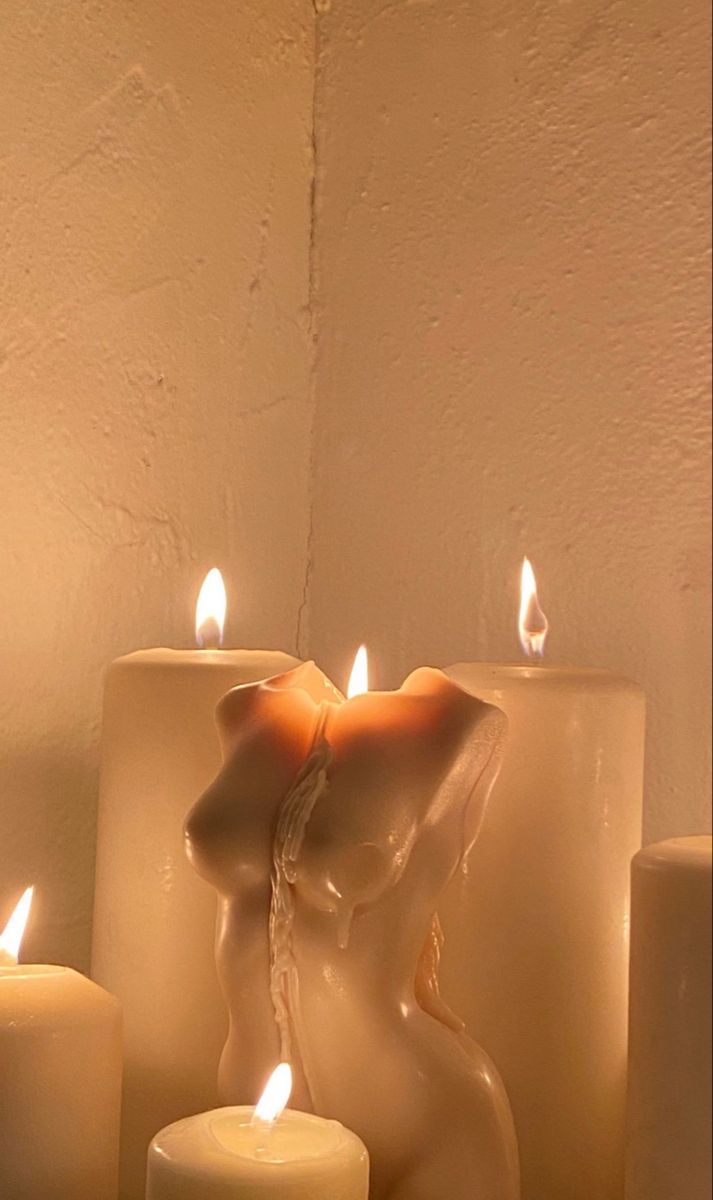 several candles are lit in front of a white wall