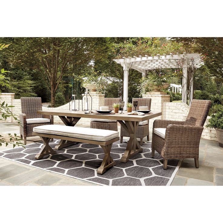 an outdoor dining table with chairs and bench