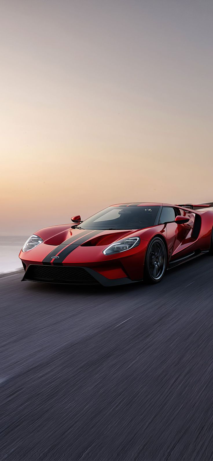 a red and black sports car driving down the road