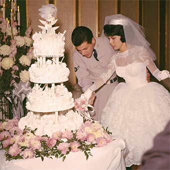 a bride and groom cutting their wedding cake