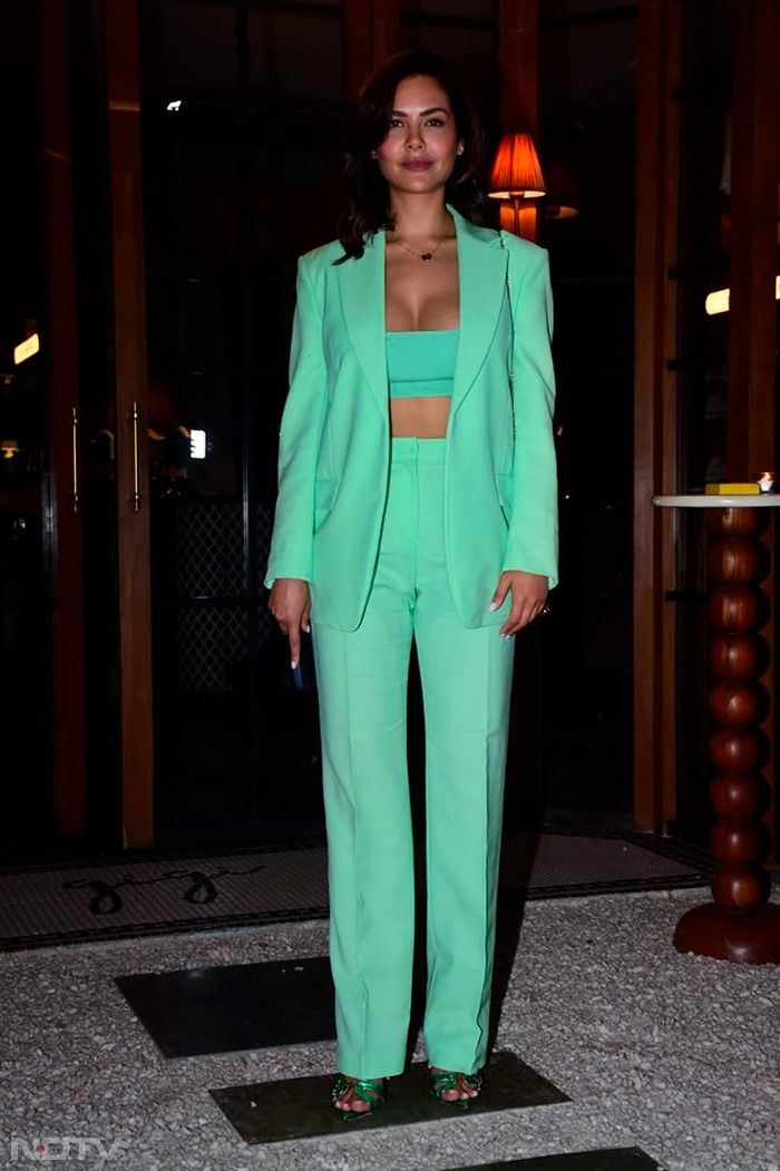 a woman in a green suit posing for the camera