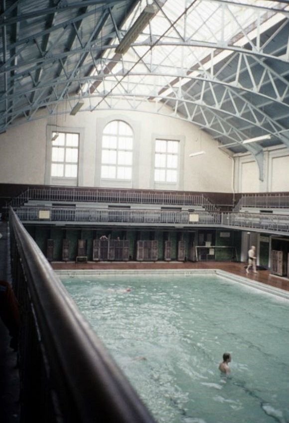 an indoor swimming pool with people in it