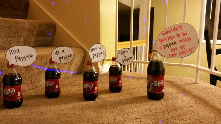 four bottles of soda sitting on top of a carpeted floor next to a stair case