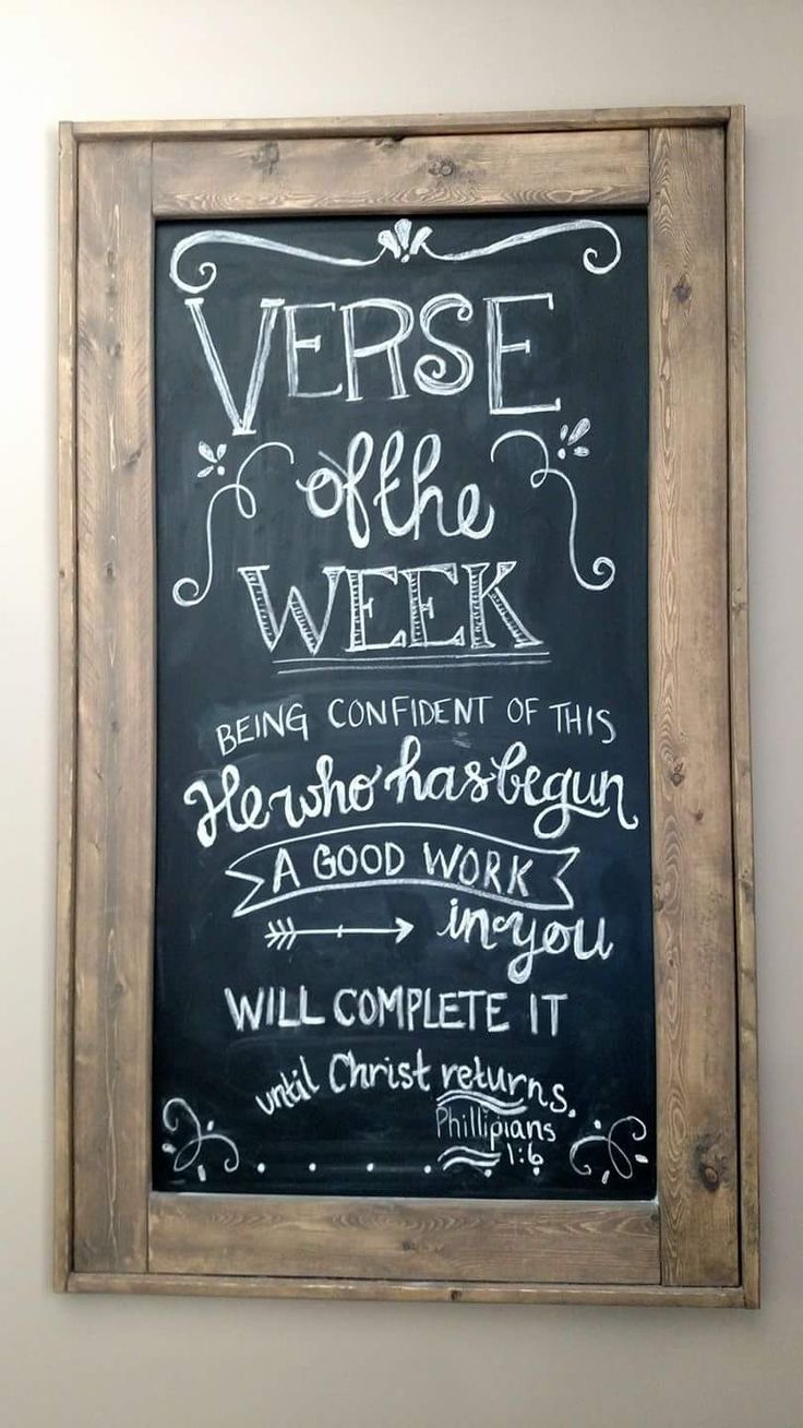 a chalkboard with writing on it in a wooden frame hanging on the wall next to a white wall