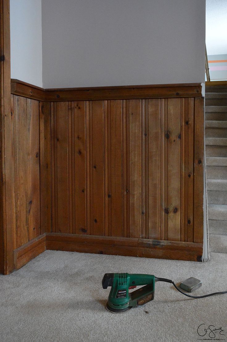 a corded sander sitting on the floor in front of a wall