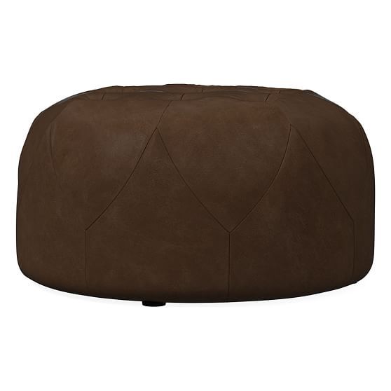 a brown leather poufce sitting on top of a white floor