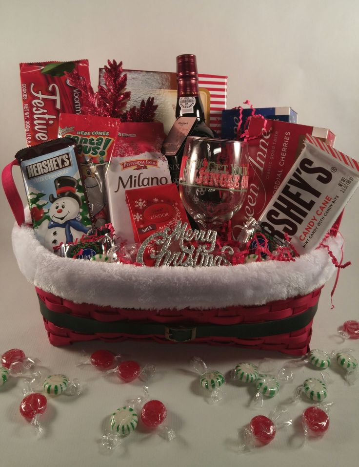 a christmas gift basket filled with wine, candy and other holiday goodie's