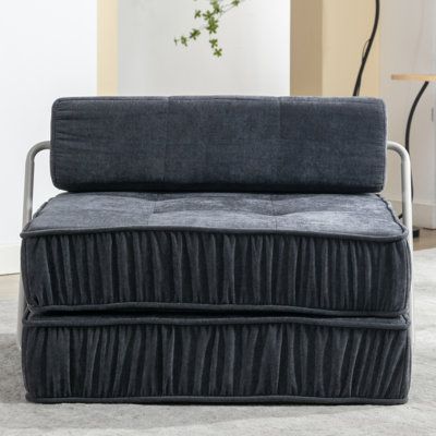 a gray couch sitting on top of a white rug