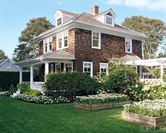 an image of a house with flowers in the front yard