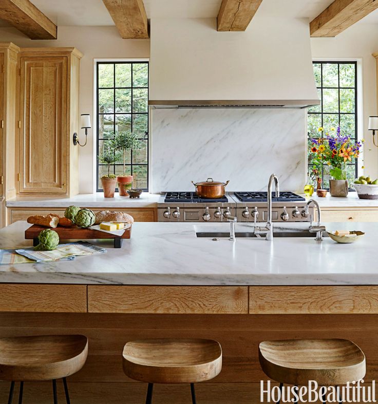 a kitchen with marble counter tops and wooden stools in front of the stove top