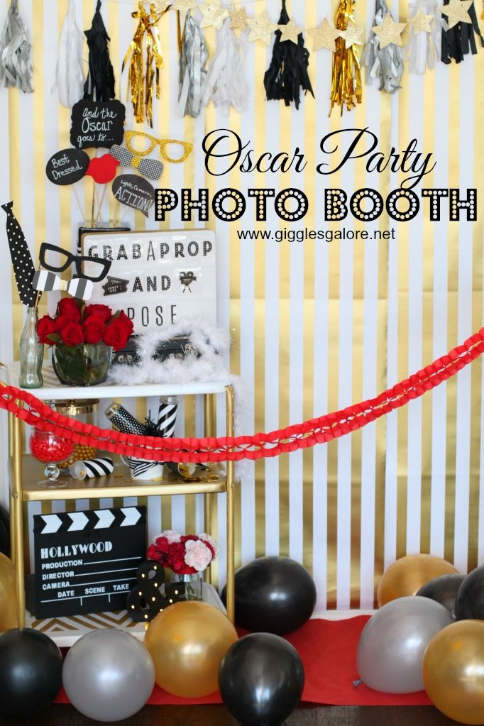 a photo booth with balloons and streamers on the wall in front of it that says, oscar party photo booth