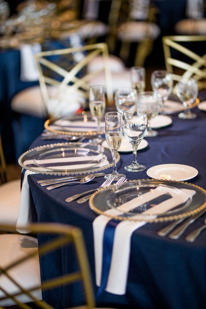 the table is set with silverware and blue linens for an elegant dinner party