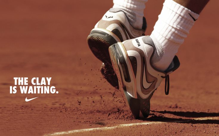 the feet of a tennis player wearing white socks and nike shoes on a clay court