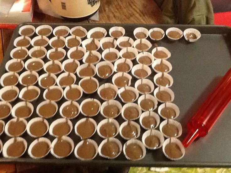 there are many cups on the tray ready to be filled with chocolates and ice cream