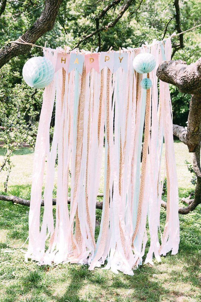 a pink and blue banner with balloons hanging from it