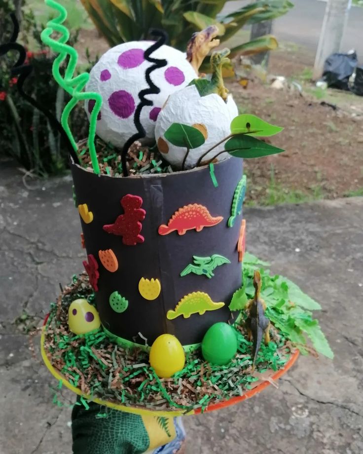 a birthday cake made to look like it is decorated with dinosaurs and balls in the grass