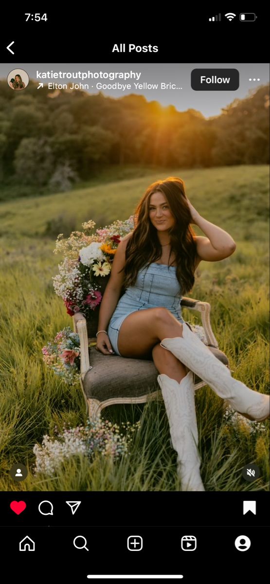 a woman sitting on top of a chair in a field