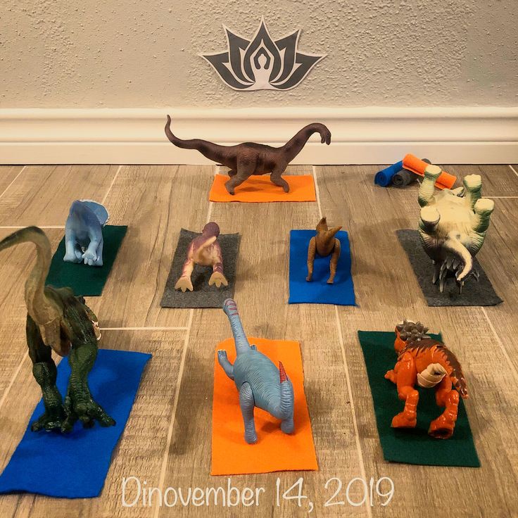 there are many toy dinosaurs on yoga mats