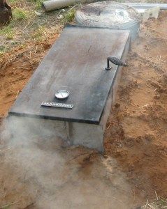 a metal bench sitting in the middle of a dirt field next to a fire hydrant