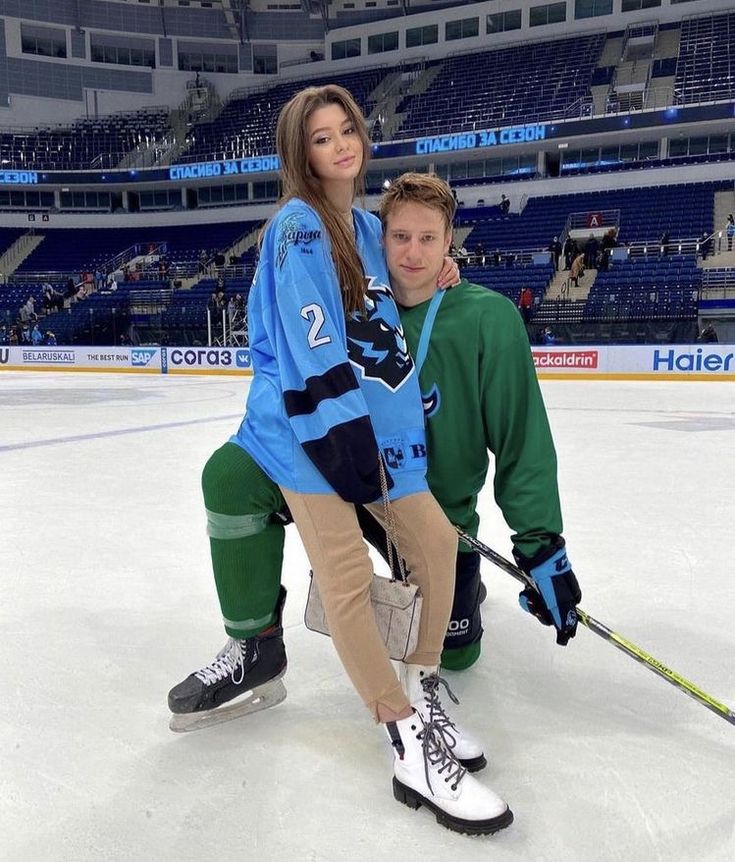 two people on an ice rink posing for a photo