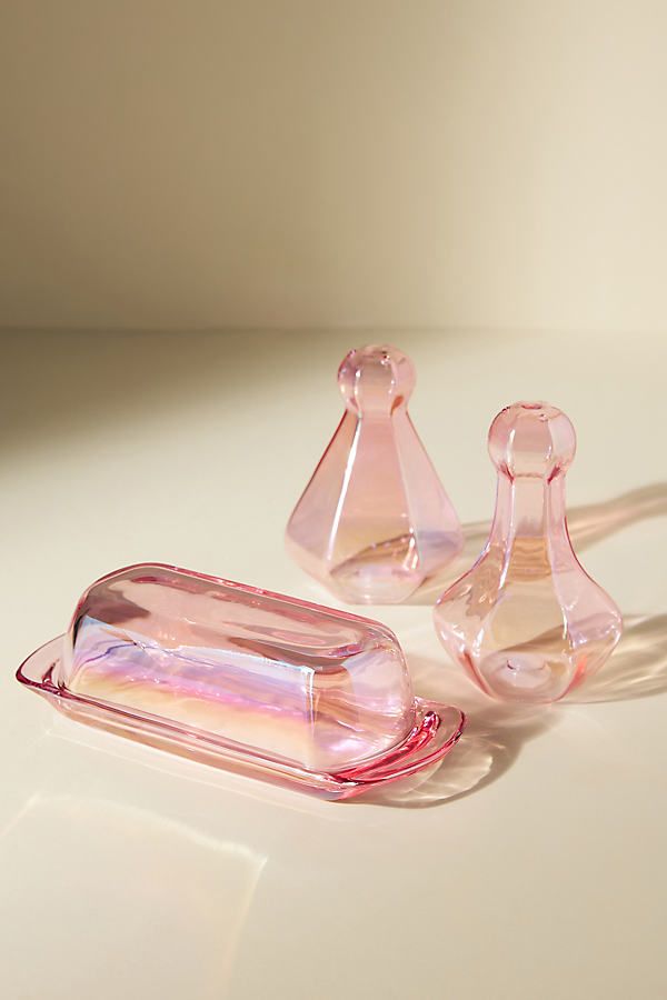 three pink glass objects sitting on top of a white table next to each other,