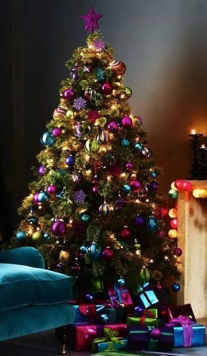 a brightly colored christmas tree with presents under it