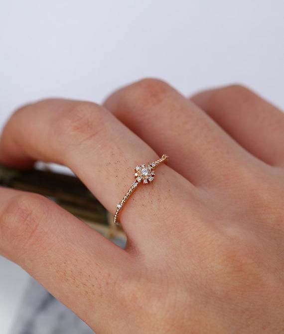 a woman's hand with a diamond ring on it