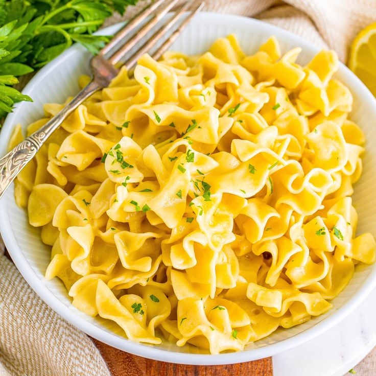 a white bowl filled with pasta and parsley