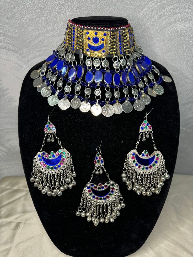 Exquisite Afghan Jewelry Set - Perfect for Special Occasions🇦🇫 Add a touch of exotic elegance to your look with our stunning Afghan jewelry set. Handcrafted by skilled artisans, each piece is a unique work of art that captures the rich cultural heritage of Afghanistan. This set includes a dazzling necklace, matching earrings, and a Tikka headpiece, all intricately designed with traditional Afghan motifs and embellished with vibrant LAPIS LAZULI gemstones. Balochi Doch Jewelry, Ceremonial Blue Meenakari Jewelry, Bohemian Beaded Chandbali Jewelry, Bohemian Chandbali Beaded Jewelry, Blue Latkans Jewelry For Festival, Traditional Adjustable Jewelry With Motifs, Adjustable Ceremonial Jewelry With Motifs, Traditional Blue Jewelry Sets, Blue Chandbali Ceremonial Jewelry