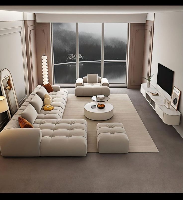 a modern living room with white furniture and large windows looking out onto the water in the distance