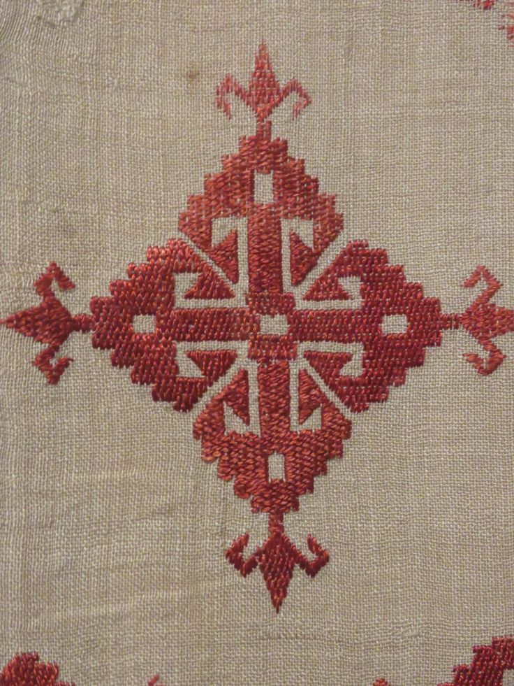 an old red and white cloth with designs on the side, in very close up